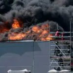 Foto mostra galpão em incêndio