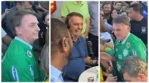 Bolsonaro usa camiseta verde enquanto tira foto com apoiadores