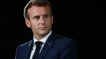 Imagem do presidente Emmanuel Macron com terno azul escuro, camisa social branca e gravata escura
