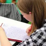 Adolescente com material escolar em mãos