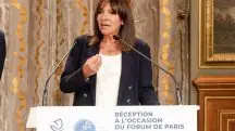 A prefeita de Paris, Anne Hidalgo, aparece em frente a púlpito, discursando em microfone. Ela, que usa roupa social, criticou Macron por convocar eleições antes das Olimpíadas