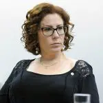 Deputada federal Carla Zambelli (PL-SP) sentada. Ela usa um vestido preto