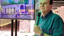 Prefeito do Rio de Janeiro, Eduardo Paes aparece vestindo camisa azul. Ele está falando em um microfone, com uma televisão ao fundo