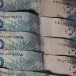 Notas de 100 reais, azuis, representando o aumento do endividamento das famílias brasileiras