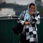 Mulher se protege do frio em rua de São Paulo