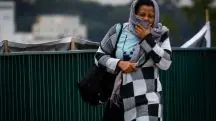Mulher se protege do frio em rua de São Paulo
