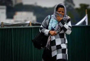Mulher se protege do frio em rua de São Paulo