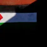 Cidadão passa por uma parede pintada com a bandeira da Palestina, no bairro de Belfast, na Irlanda do Norte - 1º/6/2024 | Foto: Nacho Doce/Reuters