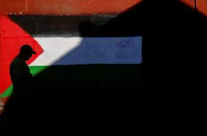 Cidadão passa por uma parede pintada com a bandeira da Palestina, no bairro de Belfast, na Irlanda do Norte - 1º/6/2024 | Foto: Nacho Doce/Reuters