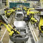 Montadora de veículos Hyundai em trabalho de fabricação de carros. Diversos robôs e "esqueletos" de carros estão na imagem