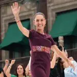 Foto mostra Claudia Sheinbaum acenando ao público durante comício