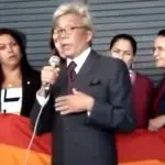 Em pé, o então deputado federal Clodovil Hernandes, que aparece de terno cinza escuro, camisa branca e gravata vinho, critica a Parada Gay; atrás dele aparece a deputada petista Maria do Rosário