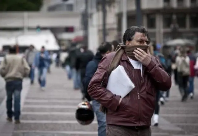 homem protegido contra o frio anda pela rua