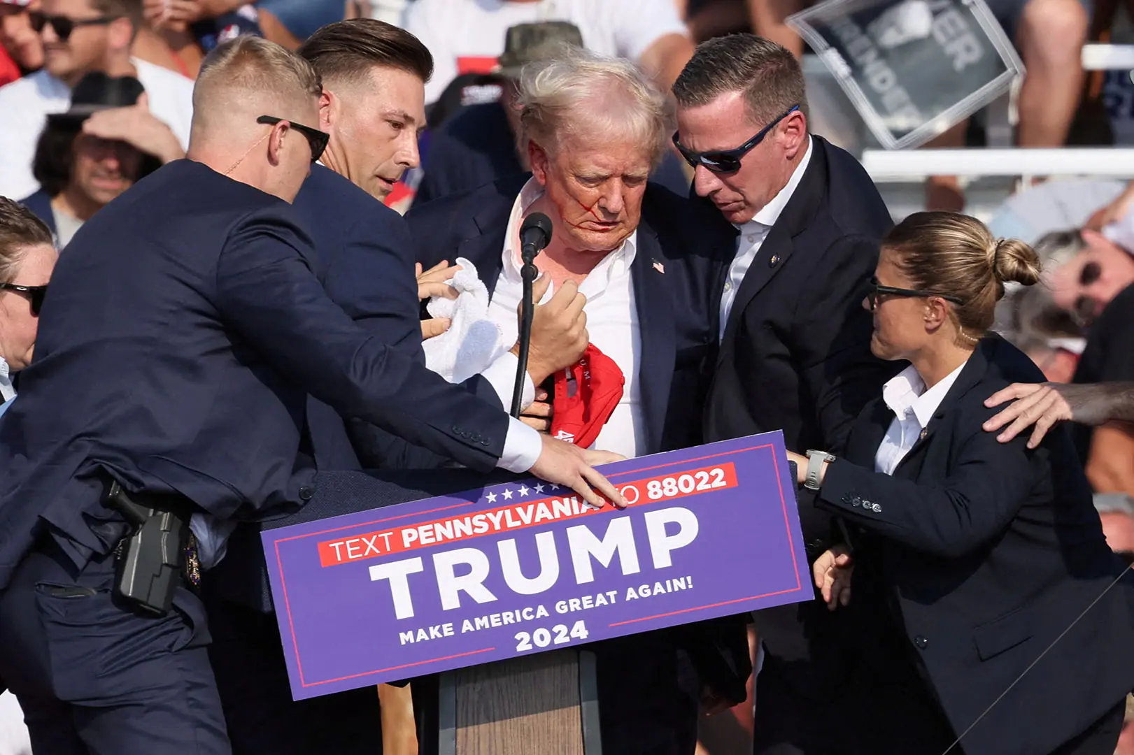 Donald Trump, candidato presidencial republicano e ex-presidente dos EUA, é auxiliado por pessoal de segurança depois de tiroteio durante um comício de campanha no Butler, Pensilvânia, EUA — 13/7/2024 | Foto: Brendan McDermid/Reuters