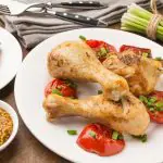 Frango assado em ângulo alto e tomate no prato, com fatias, e mostarda dijon | Foto: Reprodução/Freepik