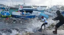 Homens puxam barcos levados pelo furacão Beryl