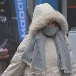 Mulher se protege de onda de frio de inverno