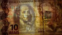 Uma cédula do real sobre uma imagem de dólar