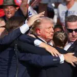 Trump gesticula, com o rosto ensanguentado, enquanto vários tiros soaram durante um comício de campanha no Butler Farm Show, em Butler, Pensilvânia - 13/7/2024 | Foto: Brendan McDermid/Reuters