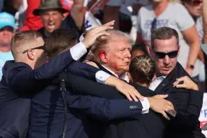 Trump gesticula, com o rosto ensanguentado, enquanto vários tiros soaram durante um comício de campanha no Butler Farm Show, em Butler, Pensilvânia - 13/7/2024 | Foto: Brendan McDermid/Reuters
