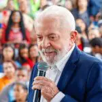 Presidente Lula veste terno azul e camisa social branca enquanto discursa