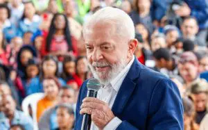 Presidente Lula veste terno azul e camisa social branca enquanto discursa