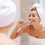 Pessoa escovando os dentes após o banho