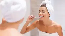 Pessoa escovando os dentes após o banho