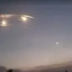 Imagem de luzes e bombardeio no céu noturno