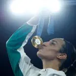 Medalhista de ouro na Olimpíada de Paris, Imane Khelif da, Argélia, beija sua medalha - mulheres no esporte | Foto: Peter Cziborra/Reuters