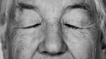Imagem mostra um senhor, em preto e branco, com os olhos fechados. Foto ilustra reportagem sobre envelhecimento