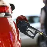 Carro de cor vermelha abastece em posto de combustível