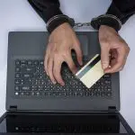 Pessoa algemada mexe em computador