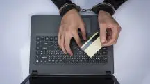 Pessoa algemada mexe em computador