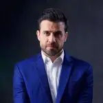 imagem de Pablo Marçal de blazer azul e camisa branca em fundo neutro cinza