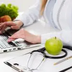 Imagem mostra uma nutricionista em consultório