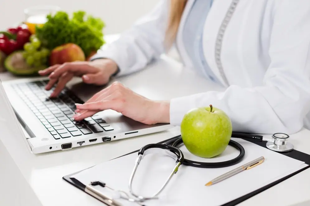 Imagem mostra uma nutricionista em consultório