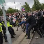 Manifestantes em confronto com a polícia na Inglaterra