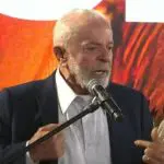 Lula veste blazer azul e camisa branca durante discurso