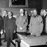 Da esquerda do leitor para a direita: Chamberlain, Daladier, Hitler, Mussolini e o ministro das Relações Exteriores da Itália, conde Galeazzo Ciano. No fundo, da esquerda para a direita: desconhecido (provavelmente um diplomata britânico), Fromageot, Ribbentrop, Weizsäcker e Leger – 29/9/1938 | Foto: Reprodução/Wikimedia Commons