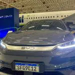 Carro da BYD com o avião da Azul ao fundo