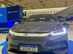 Carro da BYD com o avião da Azul ao fundo