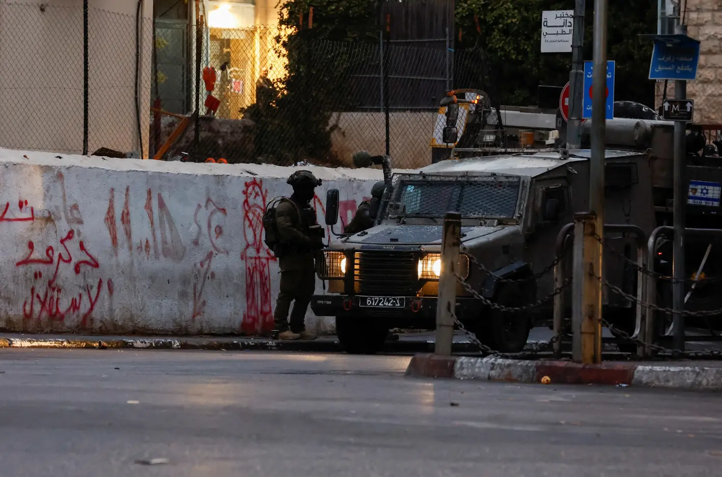 Um soldado do Exército israelense, ao lado de um veículo militar, numa rua perto do prédio onde está localizado o escritório da Al Jazeera em Ramallah, na Cisjordânia - 22/9/2024 | Mohammed Torokman/Reuters