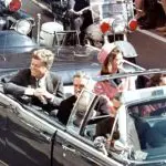JFK em sua limusine momentos antes de ser atingido por três tiros que chocariam o mundo político e produziriam inúmeras hipóteses sobre o assassinato no Texas | Foto: Domínio Público via Wikimedia Commons