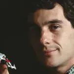 Ayrton Senna segura um modelo em escala 1:64 de seu primeiro carro vencedor do Campeonato Mundial de F1 | Foto: Reprodução/Wikimedia Commons