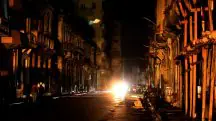 Pessoas andam na rua, à noite, enquanto Cuba é atingida por um apagão em toda a ilha, em Havana - 18/10/2024 | Foto: Norlys Perez/Reuters