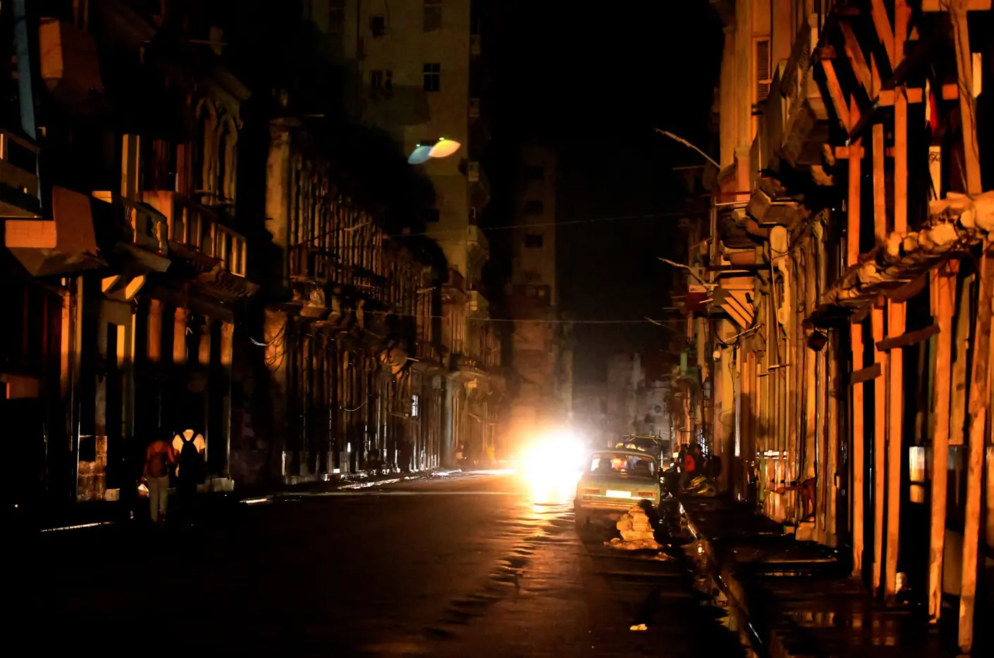 Pessoas andam na rua, à noite, enquanto Cuba é atingida por um apagão em toda a ilha, em Havana - 18/10/2024 | Foto: Norlys Perez/Reuters