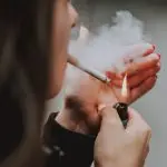 Mulher fumando cigarro, em alusão à matéria de estudo da OMS sobre tabaco