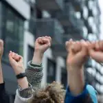 Pessoas protestam de braços levantados