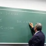 Professor escreve na lousa